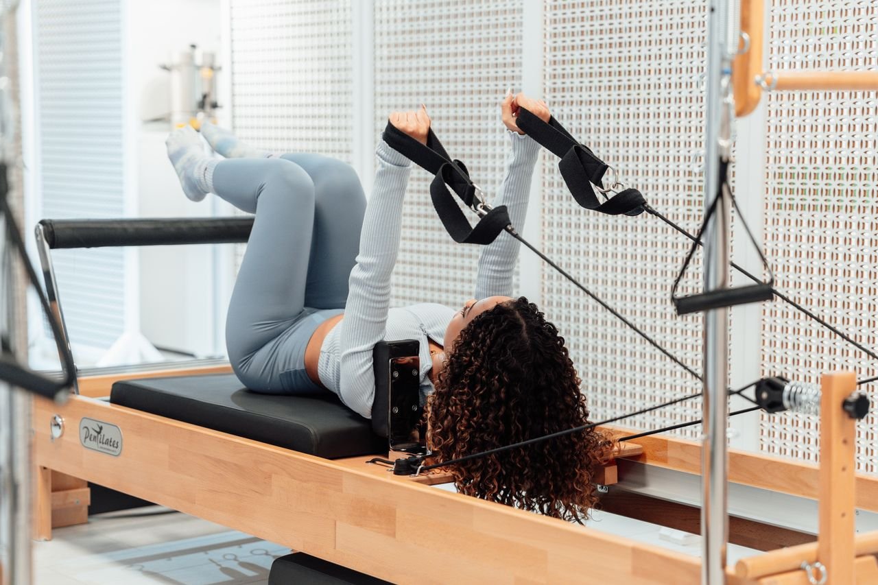 Woman practicing pilates on a tower apparatus