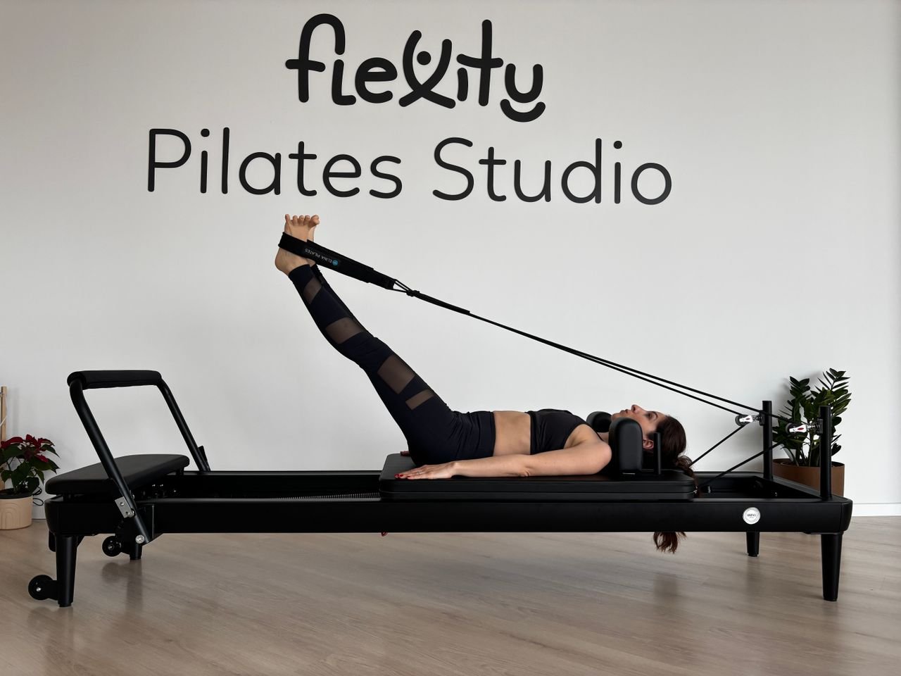 Beginner on a pilates reformer with spring resistance