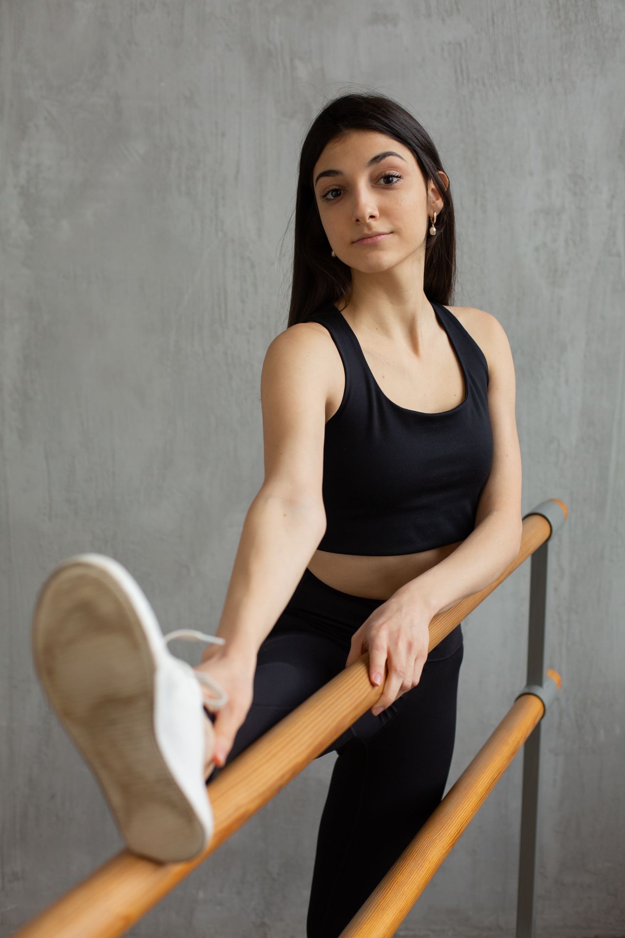 Woman stretching her leg on a barre during a low-impact barre session